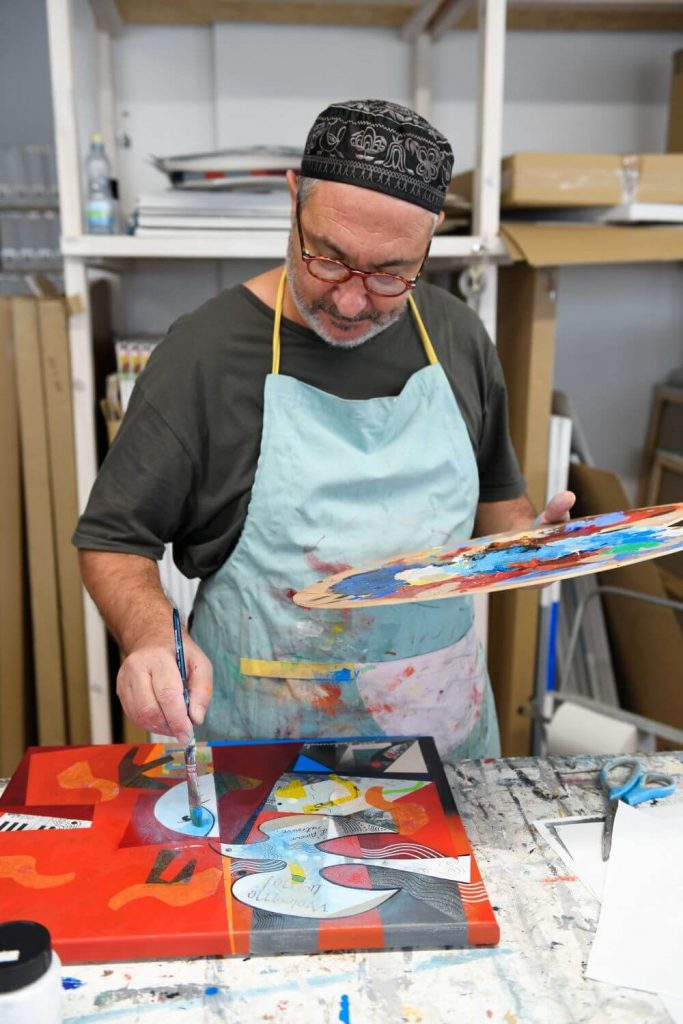Yoel Benharrouche painting at his studio table